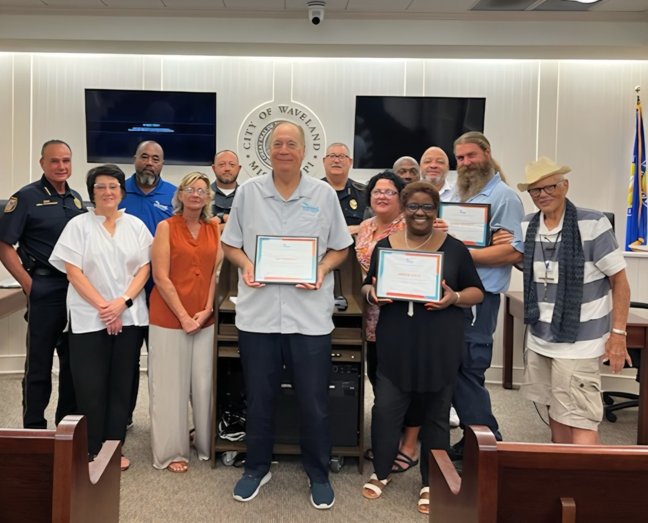 Mayor Jay Trapani with city employees and police officers holding certificates at City Hall
