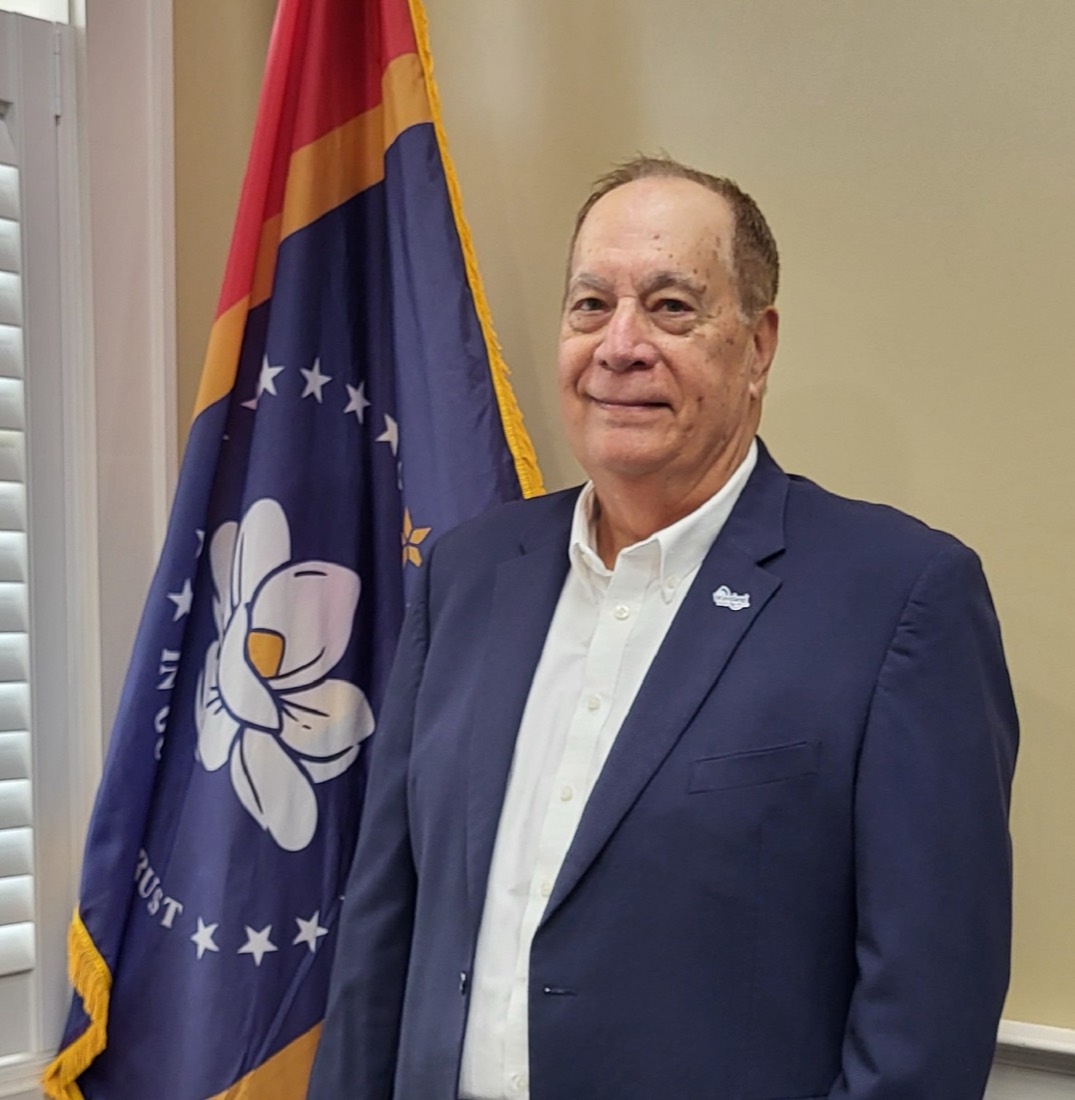 Mayor Jay Trapani beside the Mississippi state flag