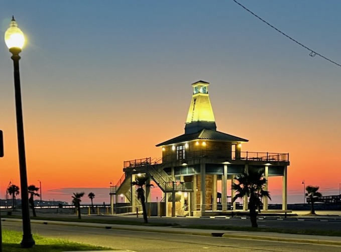 Waveland's beachfront lighthouse glowing at sunrise